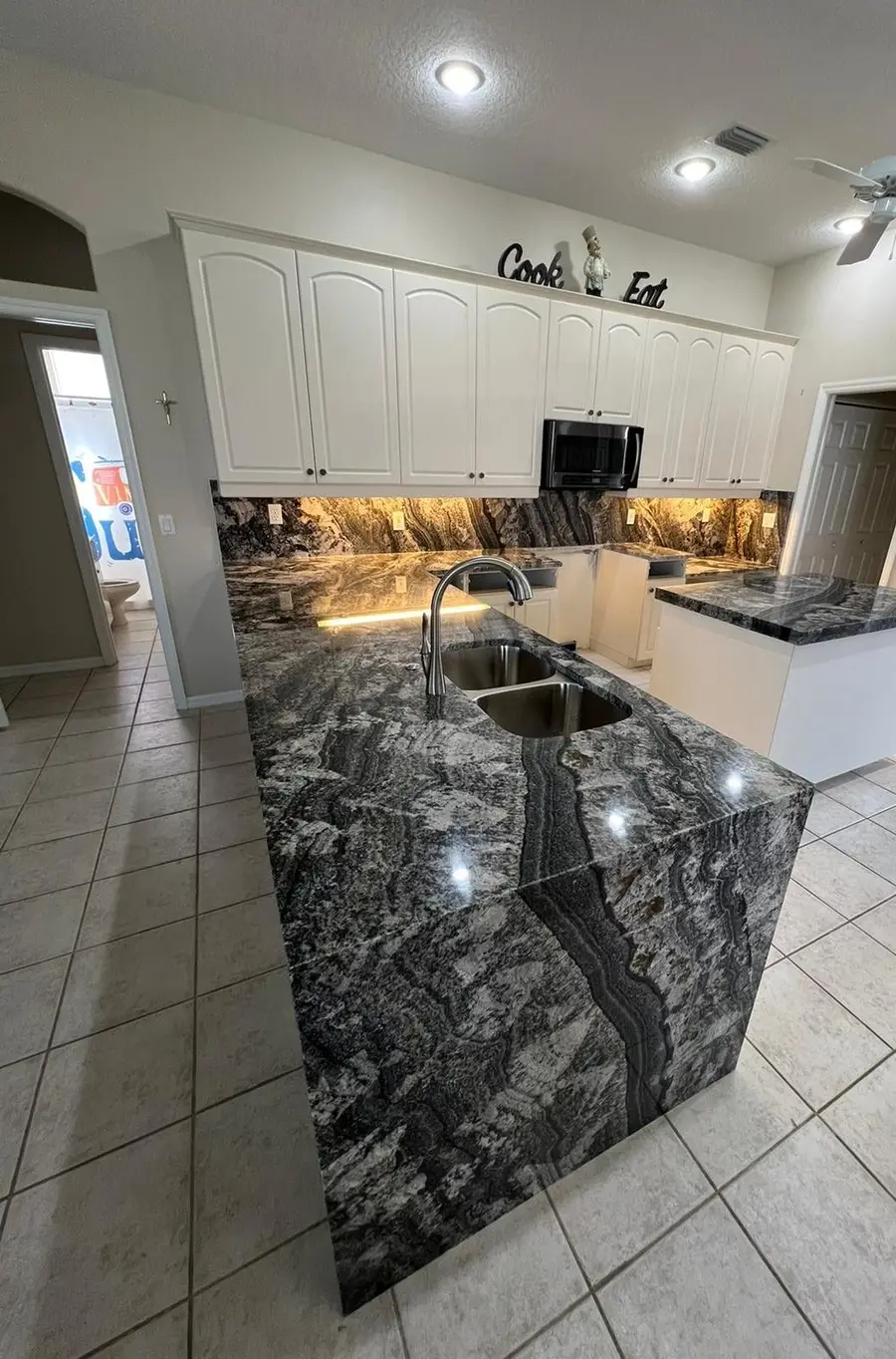 Kitchen island in dark Blue Dream granite with a waterfall side and a matching full height backsplash