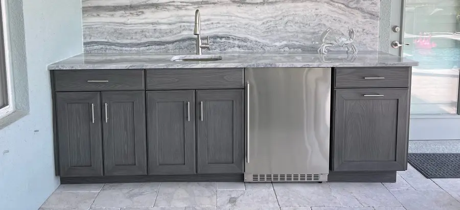 Outdoor bar with a Shadow Storm marble countertop and backsplash over gray cabinets