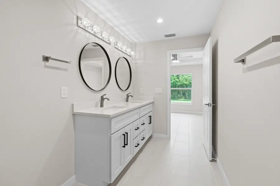 White double vanity with an Absolute White quartz top and two round mirrors