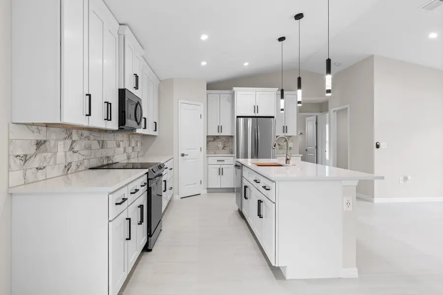 Bright white kitchen with Absolute White quartz countertops on the island and perimeter cabinets